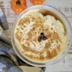 pumpkin spice espresso martini with nutmeg and coffee beans, pumpkins in the background
