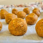 protein balls on a parchment lined baking sheet