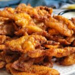 crispy chicken skin chips piled on a plate.