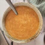 bowl of tomato soup with grated parmesan cheese, mandolin, bowl of parmesan cheese