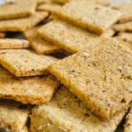 crackers piled onto a parchment lined baking sheet