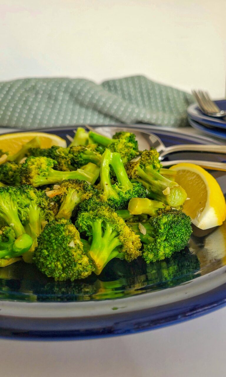 cooked broccoli on a plate with lemon