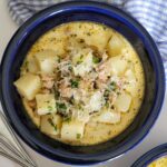 bowl of sausage and potato soup with parmesan and chopped parsley