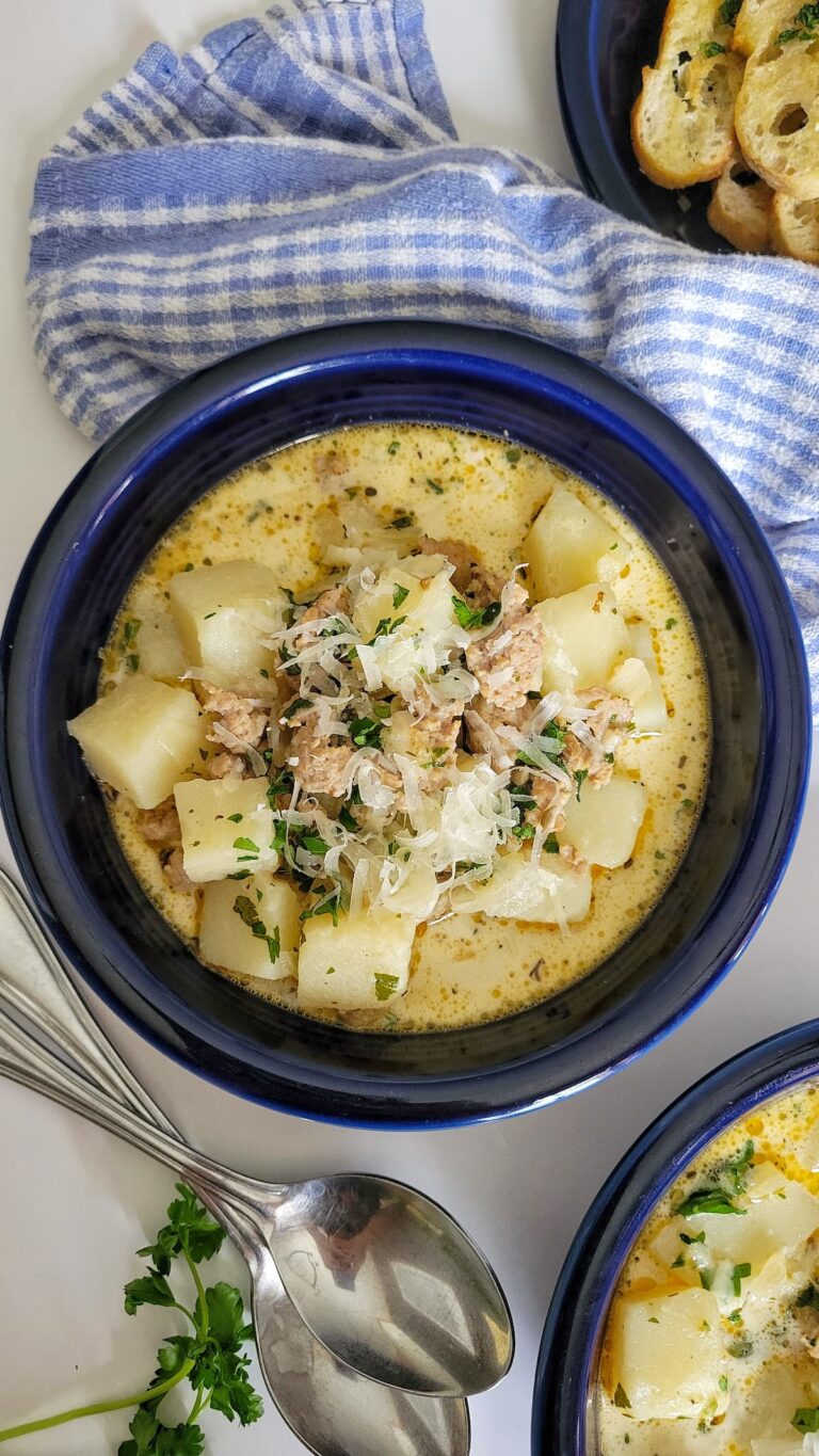 bowl of sausage and potato soup with parmesan and chopped parsley