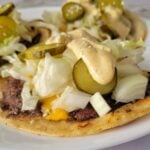 big mac smash tacos with pickles, mac sauce, cheese, sesame seeds, lettuce, and onions