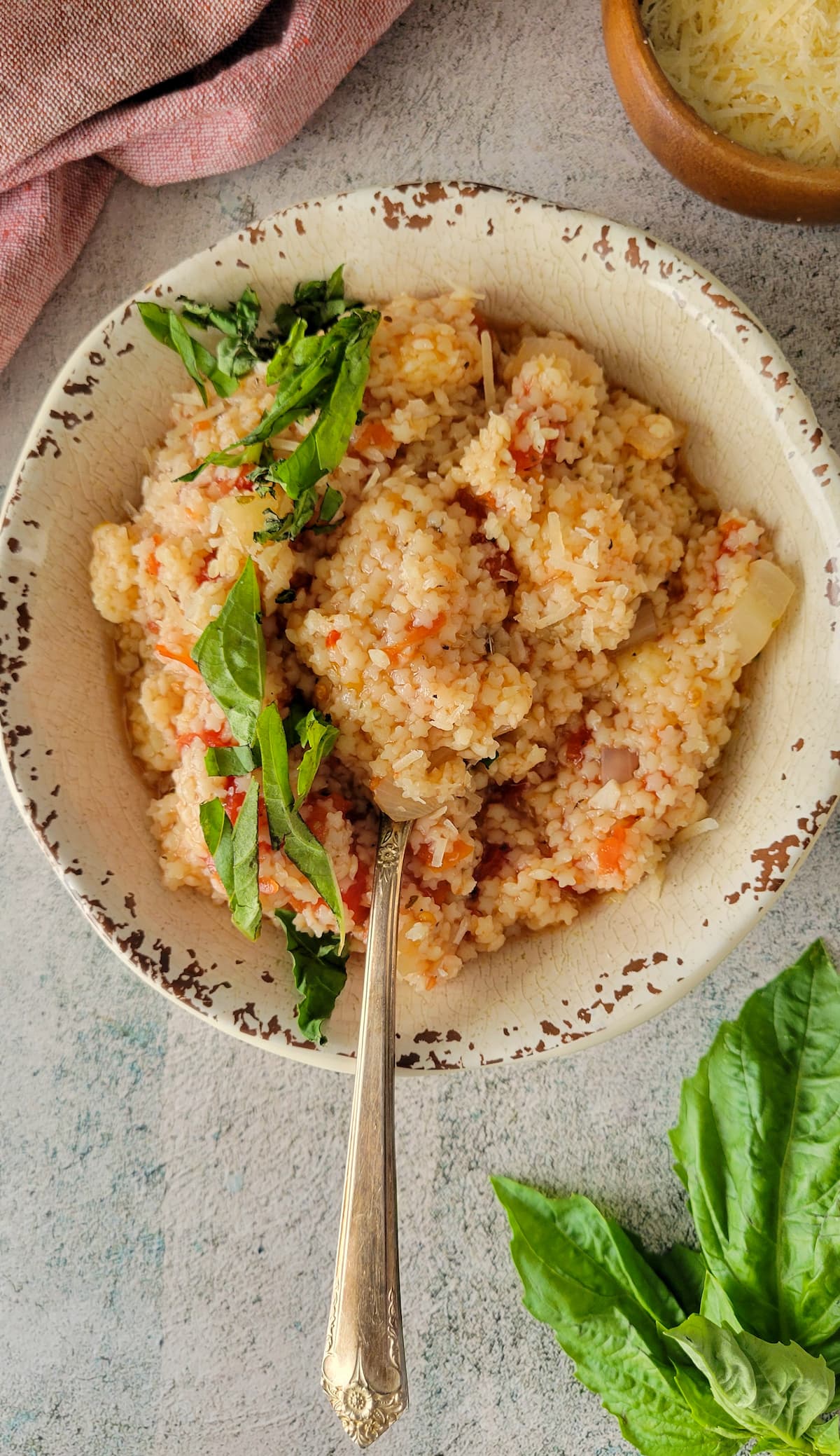 bowl of tomato pastina with basil and a spoon