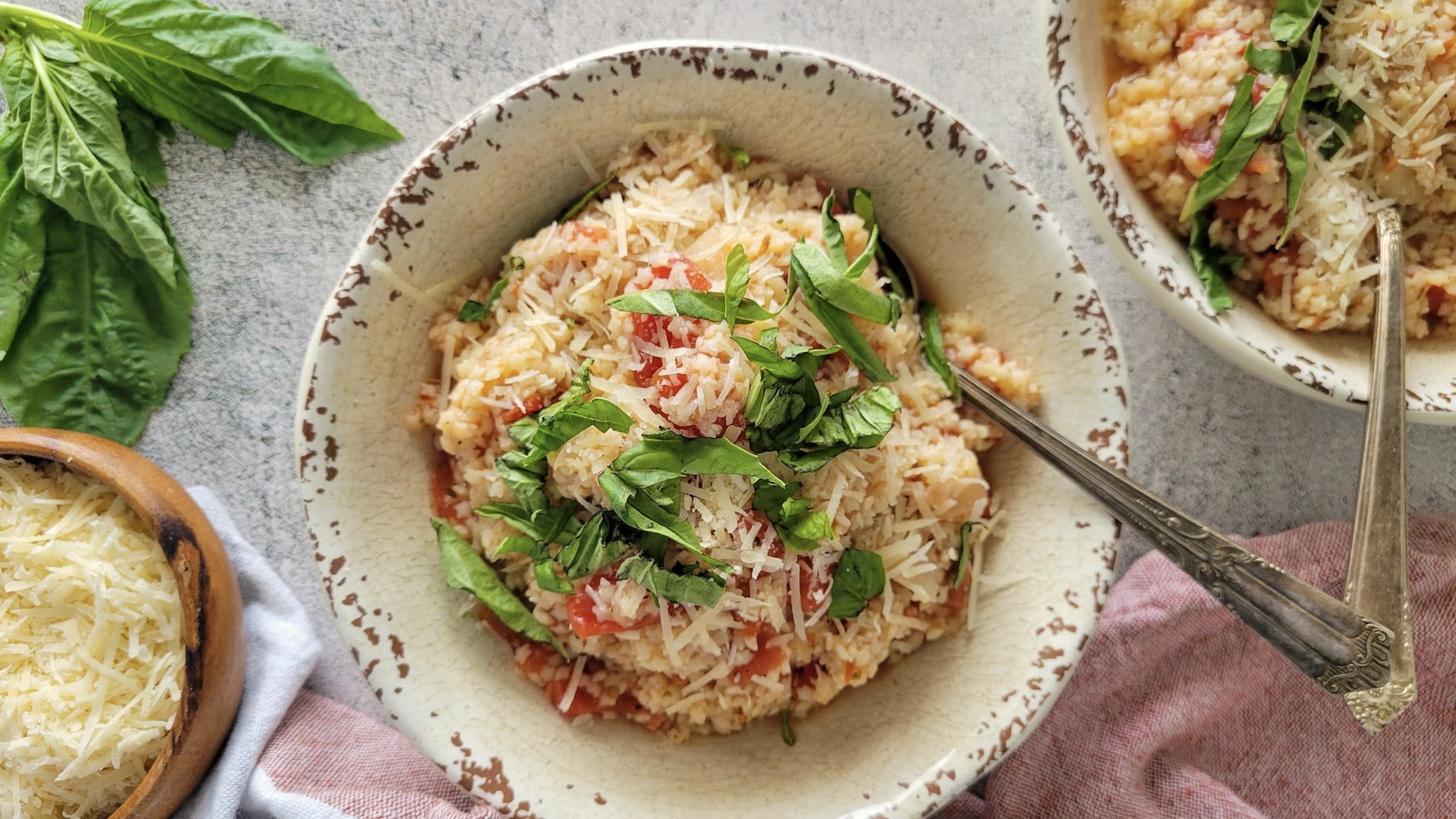 two bowls of tomato pastina with fresh basil and parmesan cheese
