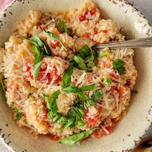 tomato pastina in a bowl with fresh chopped basil