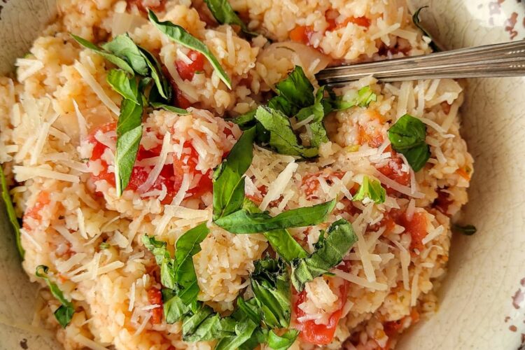 tomato pastina in a bowl with fresh chopped basil