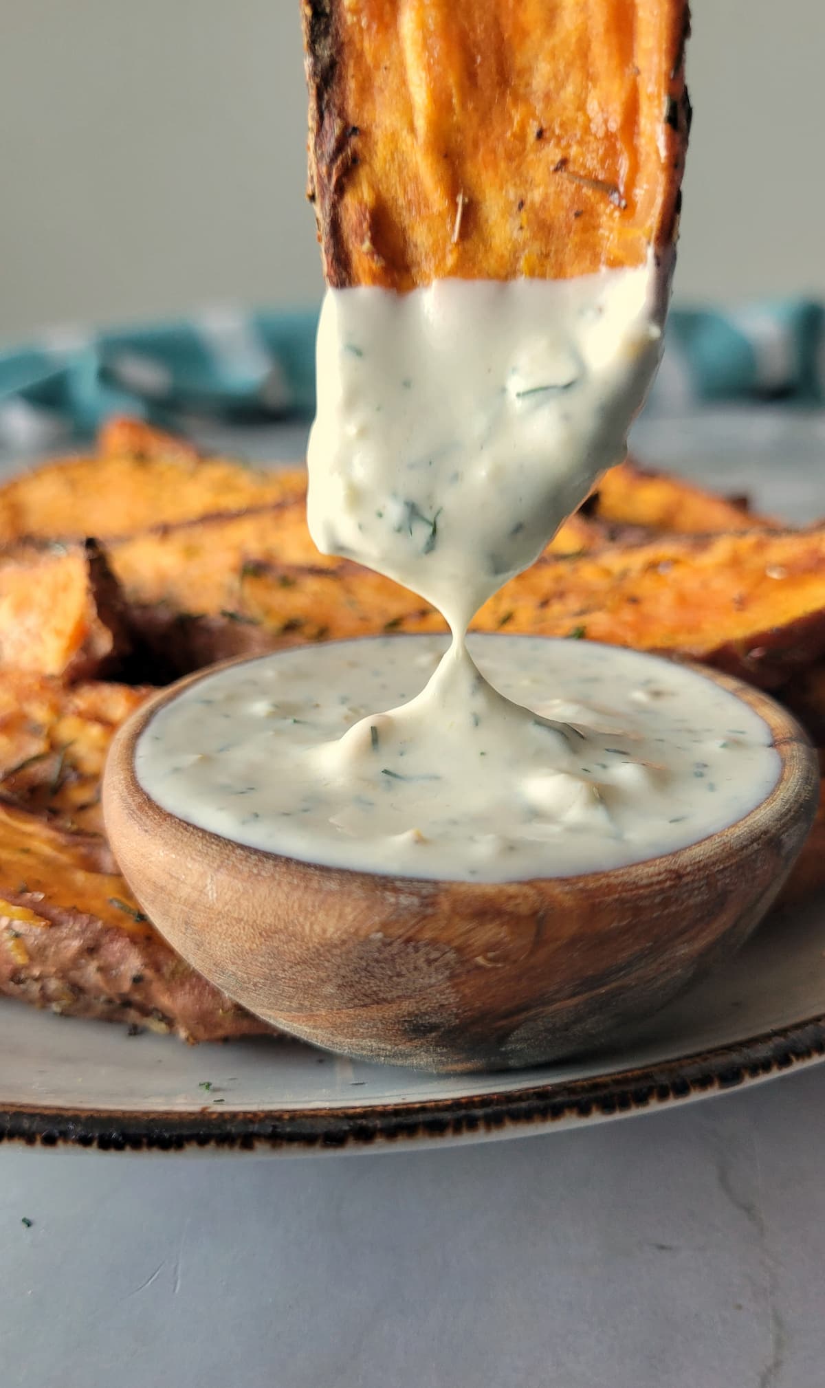 sweet potato wedge dipping into a white creamy sauce