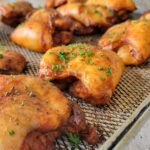 chicken thighs with fresh chopped parsley on an air fryer tray