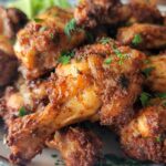 blackened wings on a plate with fresh chopped parsley