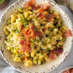 pasta with peas, crispy prosciutto in a bowl, parmesan, lemon zest, parsley, in the background