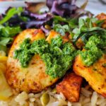 halloumi cheese with parsley sauce on a plate with sweet potatoes, rice, and greens