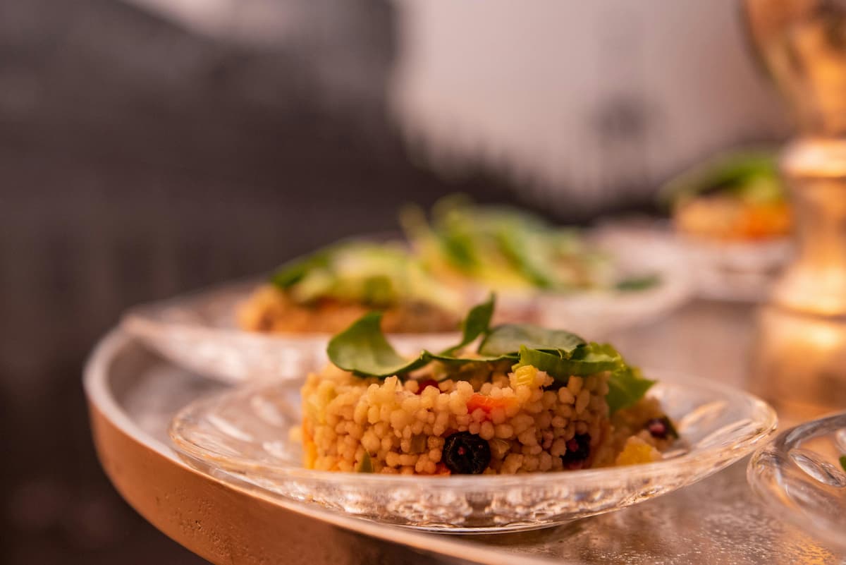 plate of fregola with herbs and olives