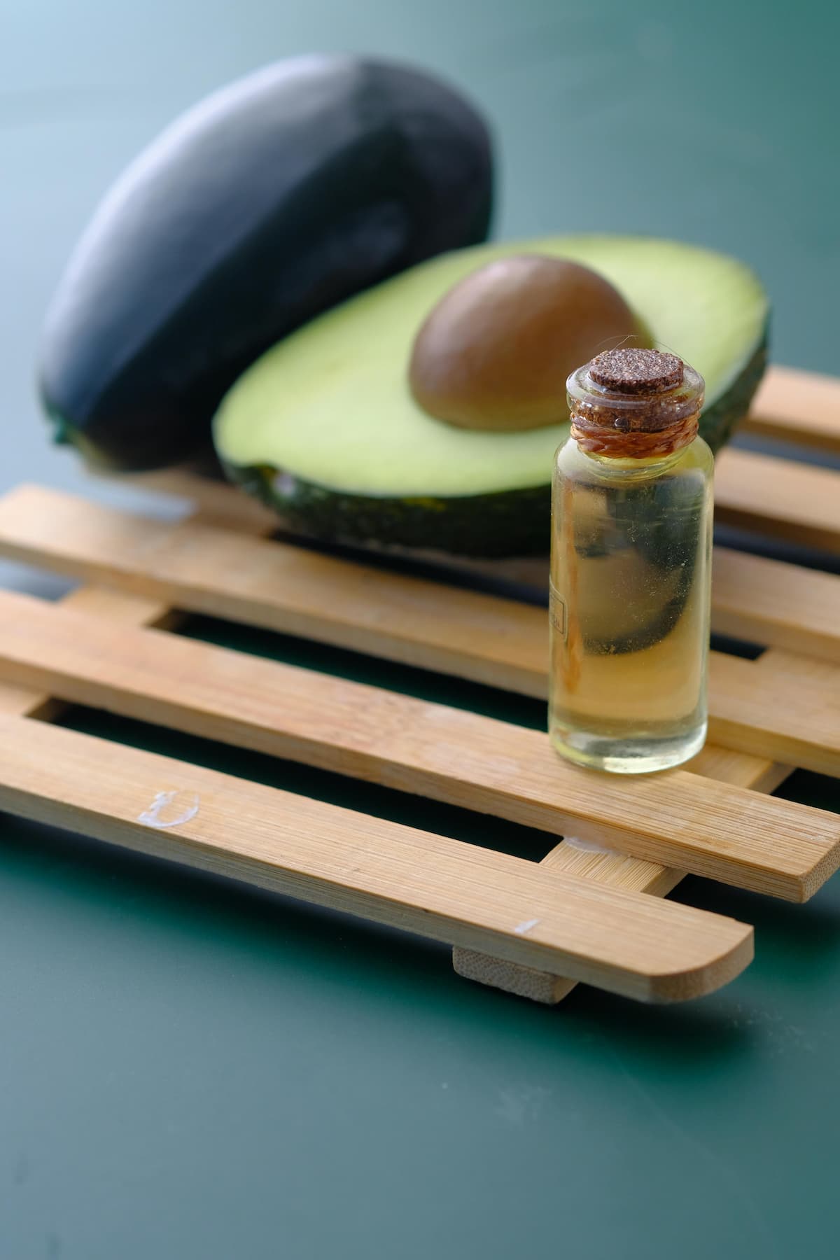 bottle of avocado oil next to avocados