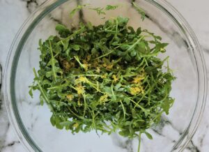 arugula in a bowl with lemon zest