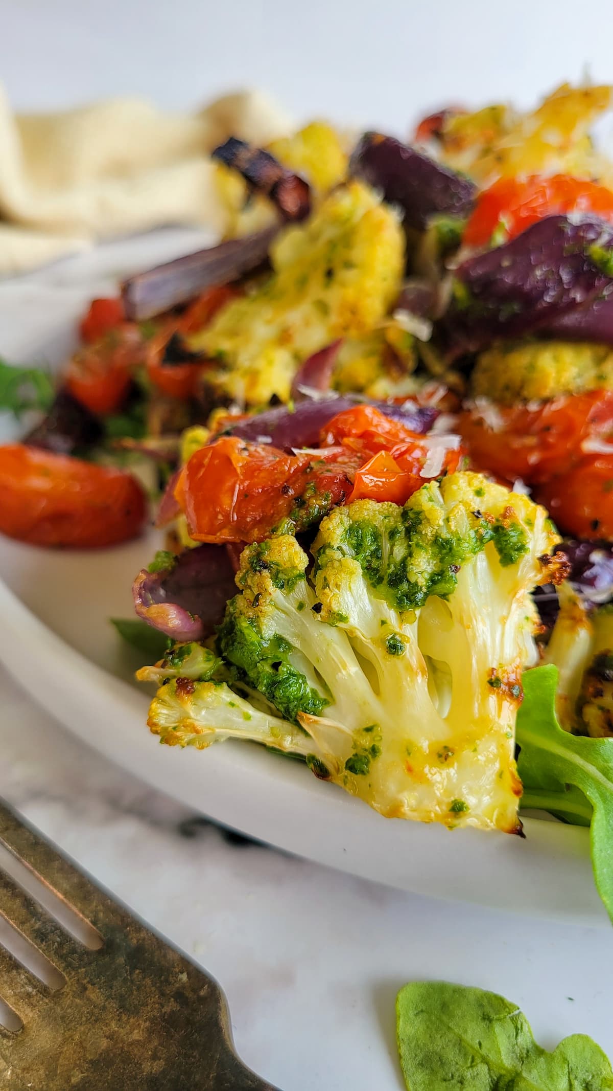 pesto cauliflower with cherry tomatoes and red onions on a plate