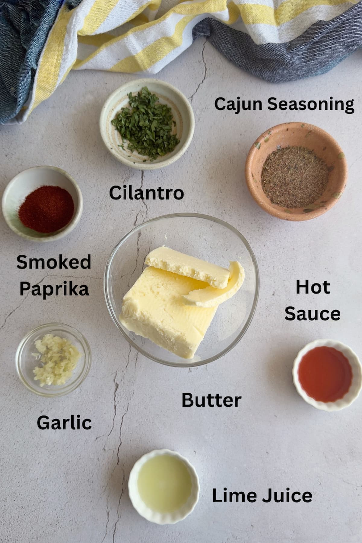 ingredients for cajun butter - cajun seasoning, butter, hot sauce, lime juice, cilantro, smoked paprika, garlic