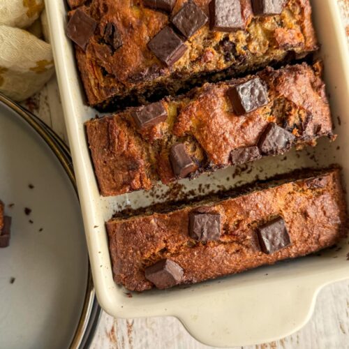cooked sliced banana bread with chocolate chunks in a loaf pan