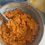 orange whipped butter in a bowl with a fork