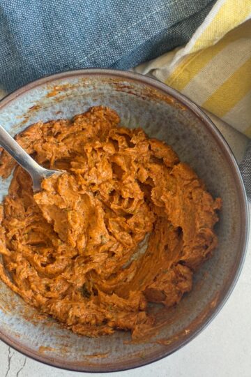orange whipped butter in a bowl with a fork