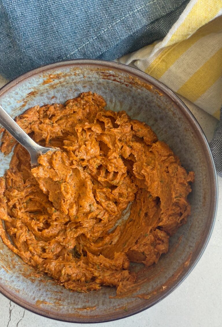 orange whipped butter in a bowl with a fork