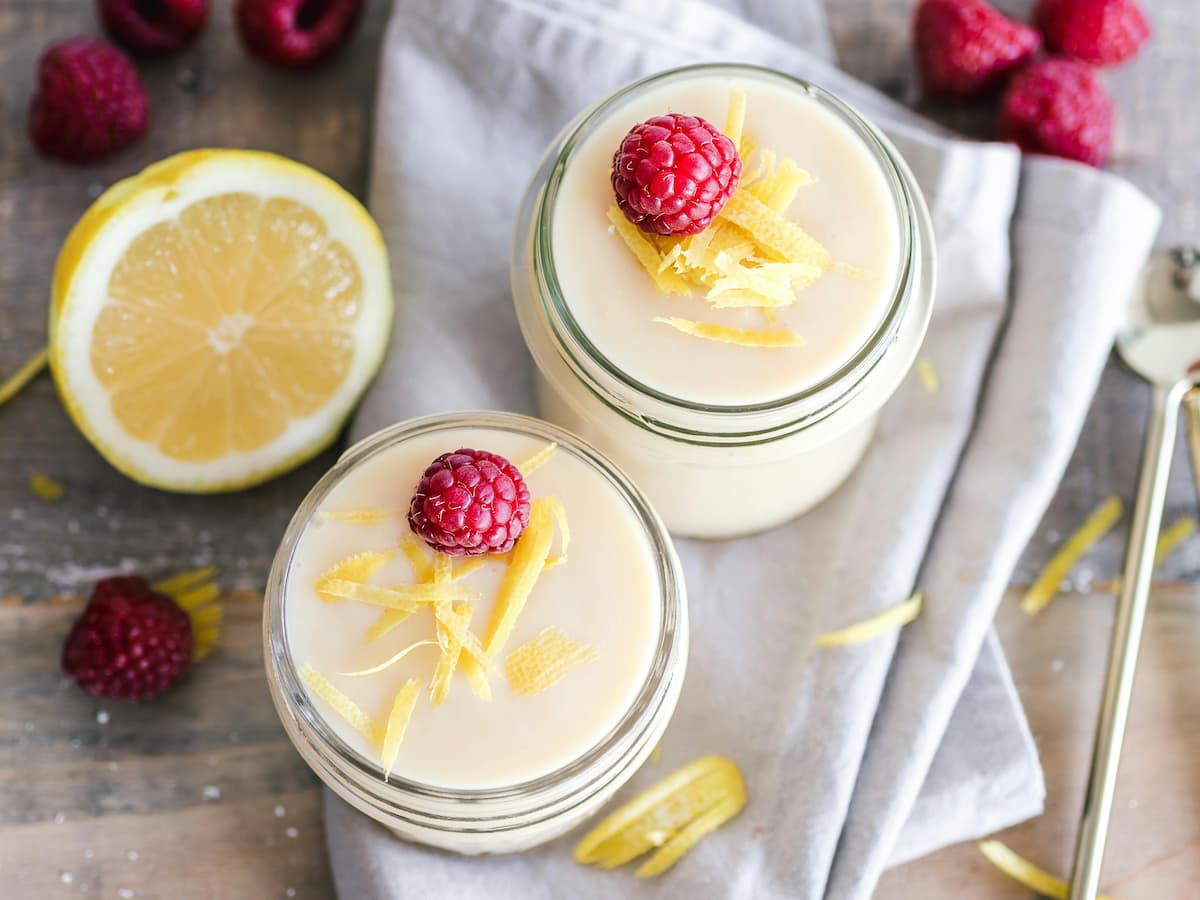 lemon yogurt in jars with raspberries and lemon shavings