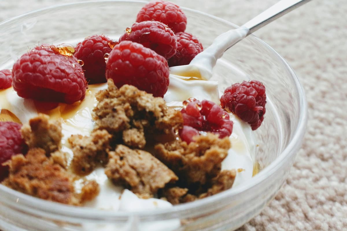 greek yogurt bowl with honey, raspberries, and granola