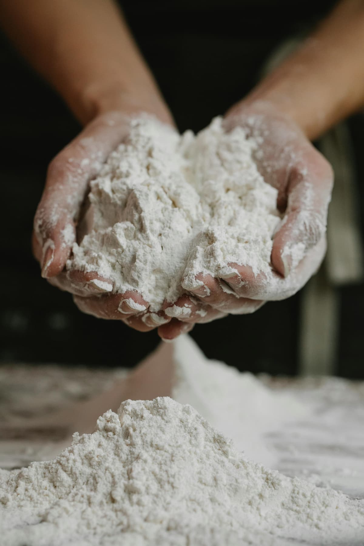 flour in hands over a pile of more