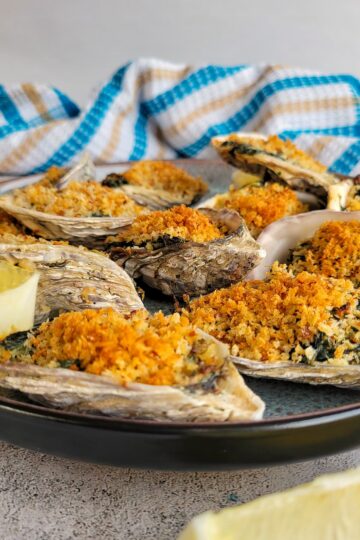 oysters rockerfeller on a plate with lemon