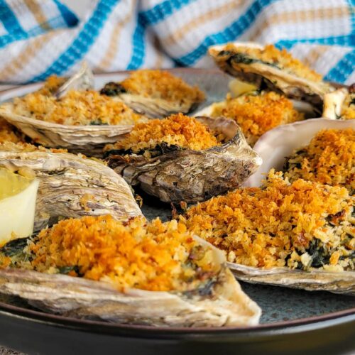 oysters rockerfeller on a plate with lemon