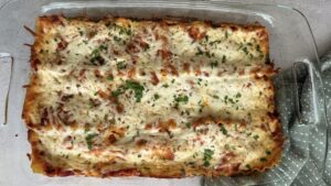 cooked lasagna in a baking dish with fresh chopped parsley on top