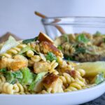 caesar pasta salad on a plate, bowl with more in the background