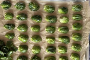 raw seasoned brussel sprouts cut side down in a single layer on a parchment lined baking sheet