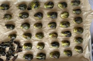 roasted brussels sprouts in a single layer on a parchment lined baking sheet