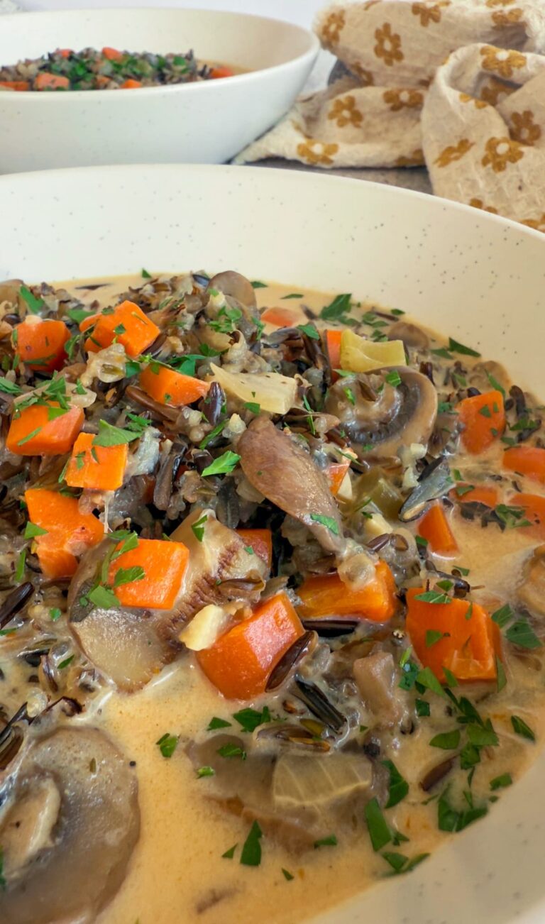 bowl of creamy soup with mushrooms, carrots, celery, onions, wild rice, and parsley