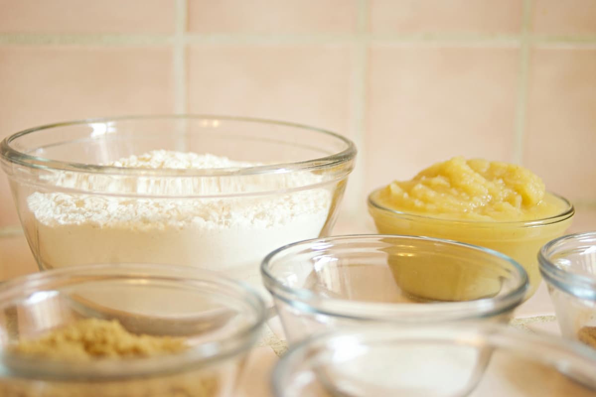 baking ingredients like flour, sugar, and applesauce in bowls