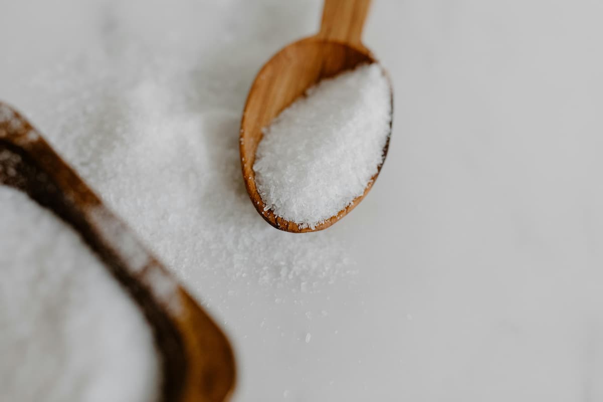 salt in a wooden spoon on top of a pile of salt