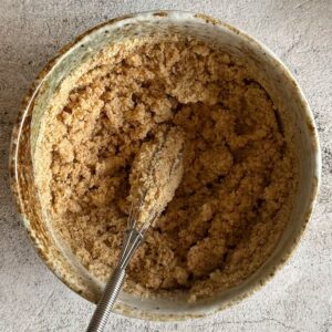 milk and breadcrumb mixture in a bowl with a whisk