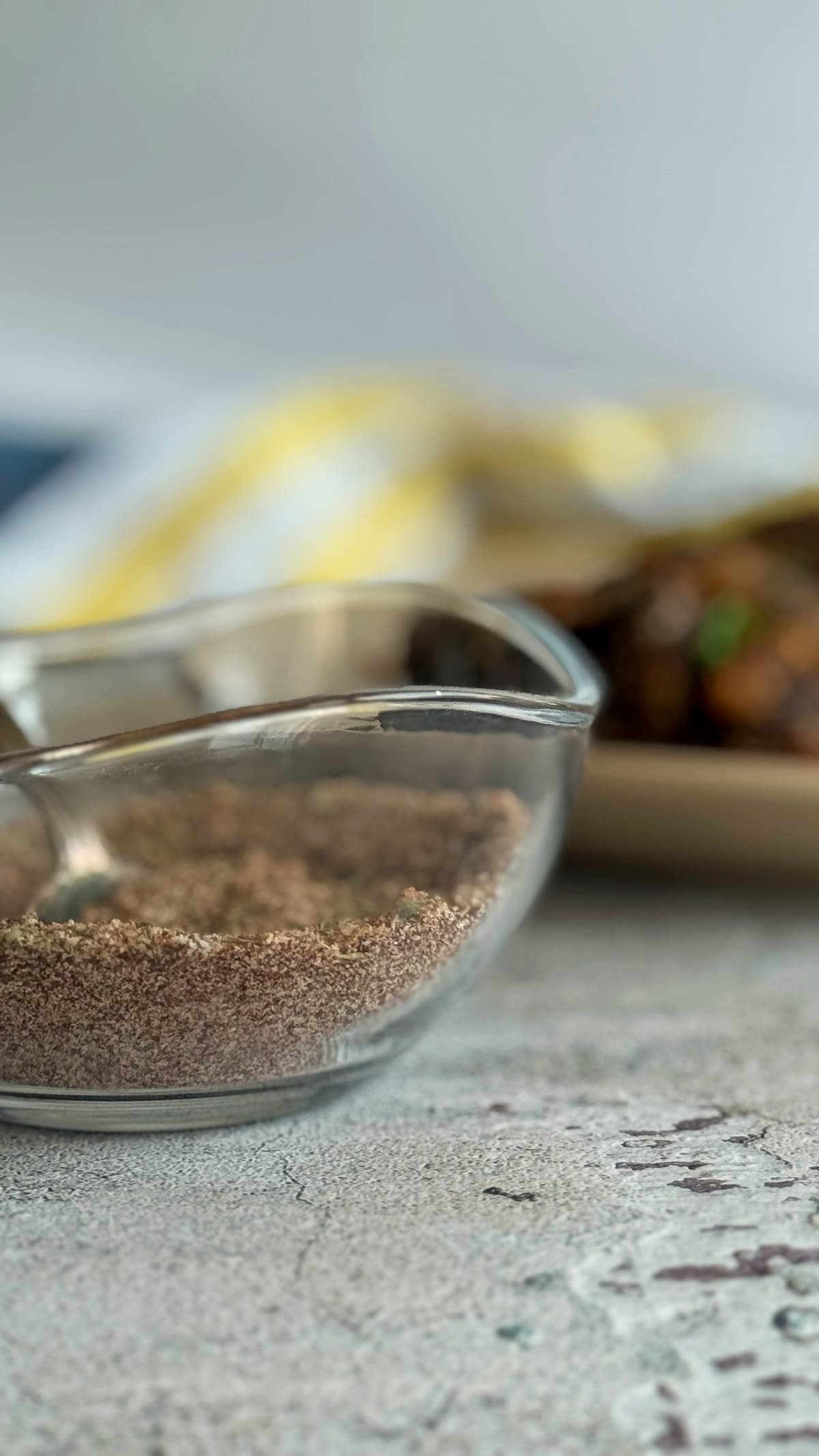 seasoning in a bowl in front of a cooked meatloaf