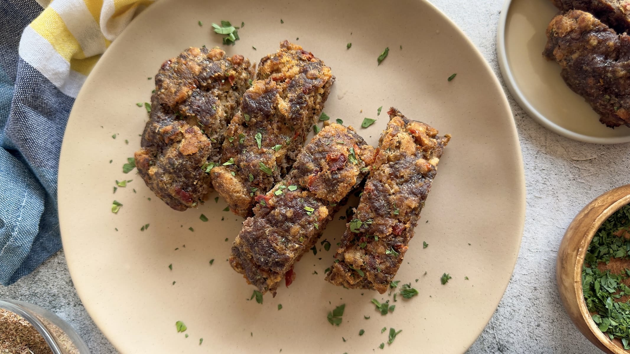 sliced meatloaf on a plate with chopped fresh parsley