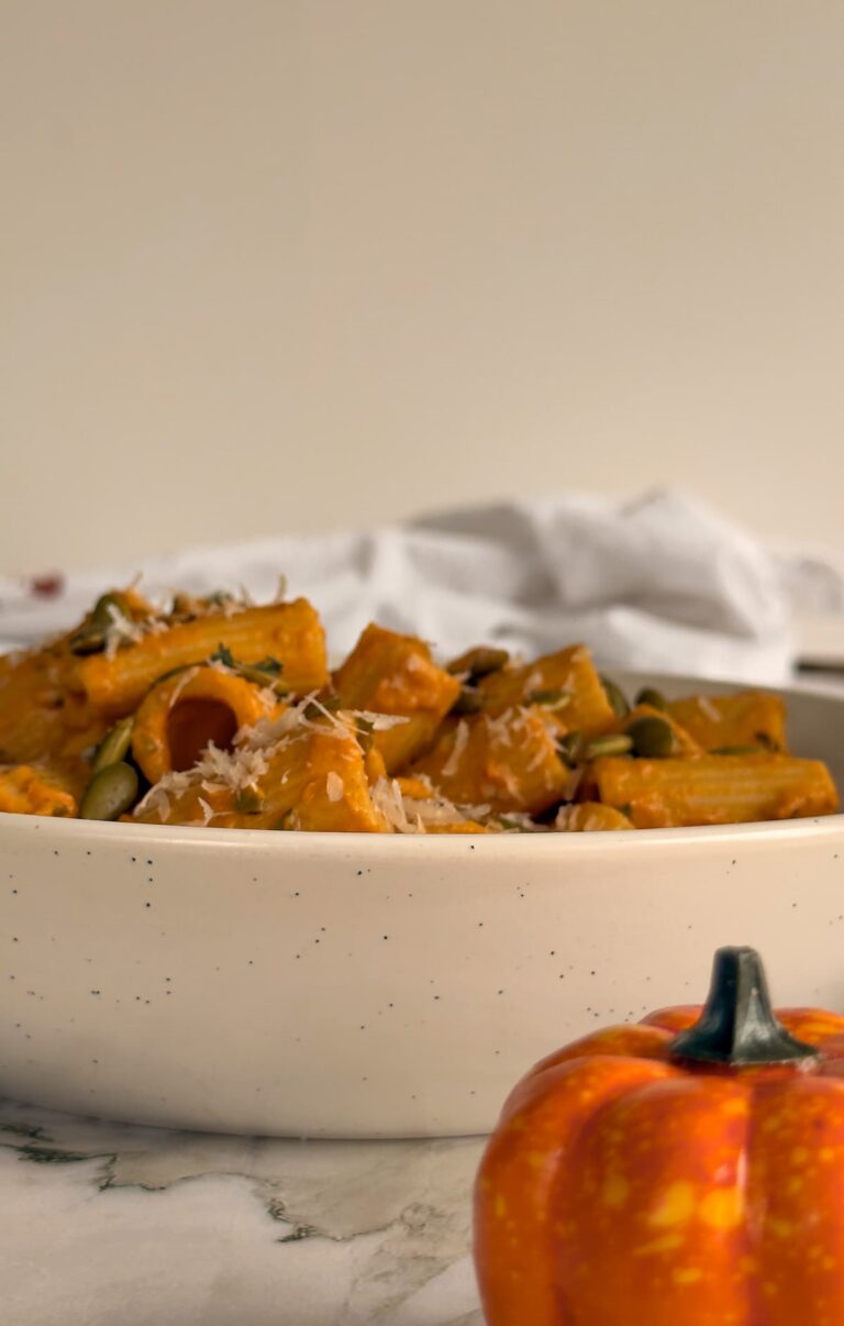 rigatoni in pumpkin sauce with pepitas and parmesan in a bowl