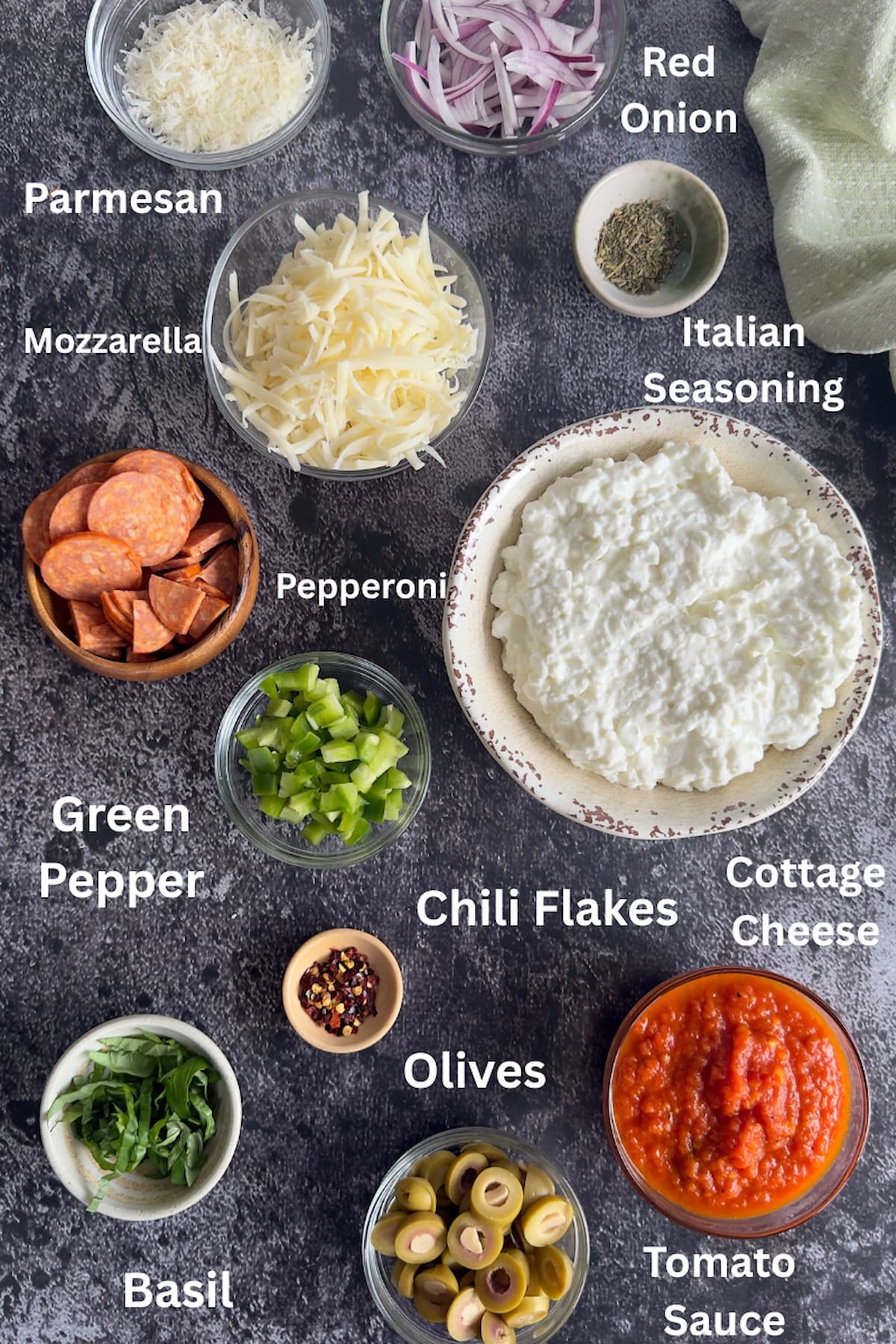 ingredients for cottage cheese pizza bowl - parmesan, mozzarella, red onion, cottage cheese, italian seasoning, pepperoni, green pepper, chili flakes, tomato sauce, basil