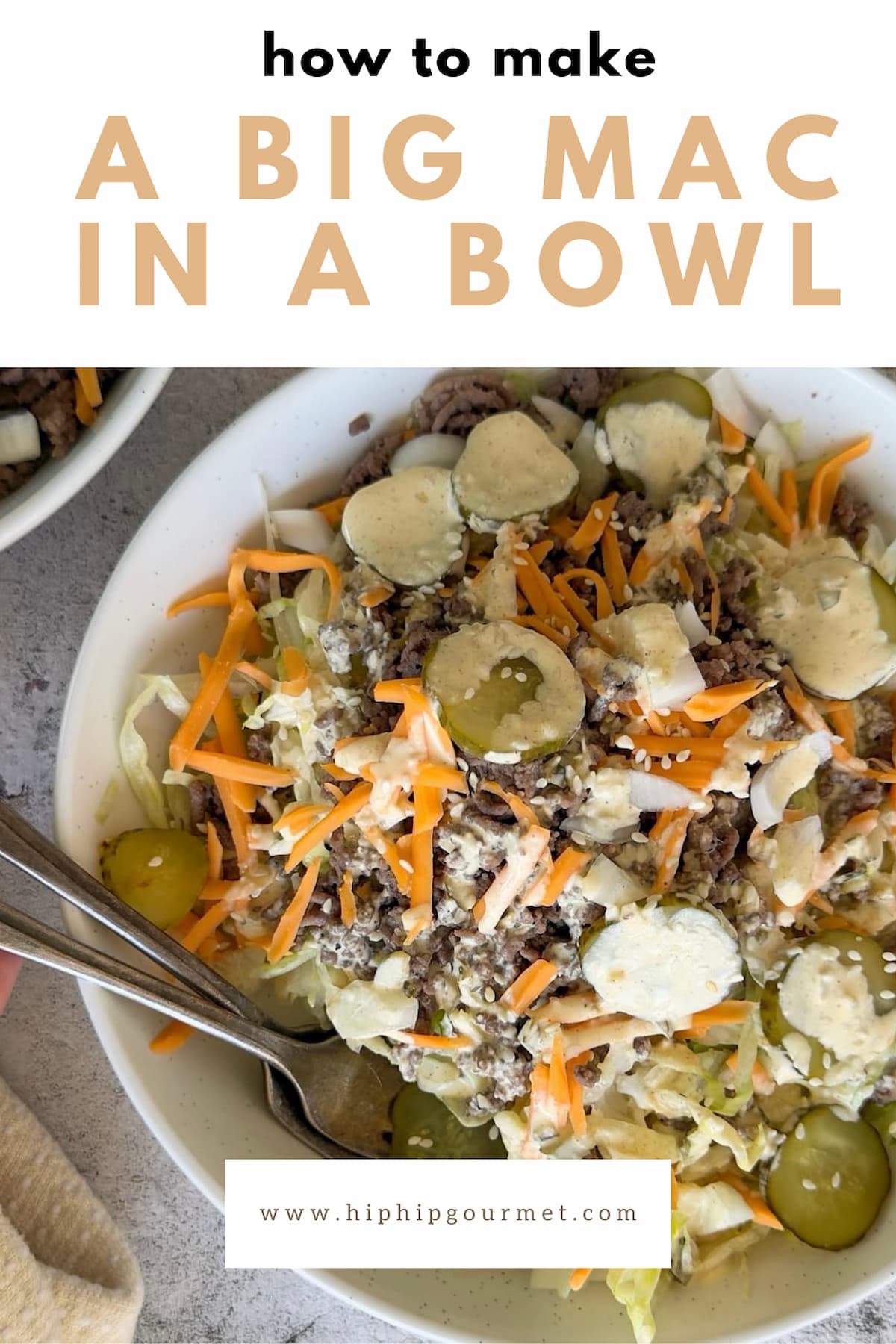 two forks in a bowl of big mac salad. Sliced pickles, grated cheddar, ground beef, sesame seeds, and mac sauce in the bowl.