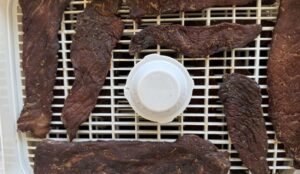 beef jerky slices on a dehydrator tray.