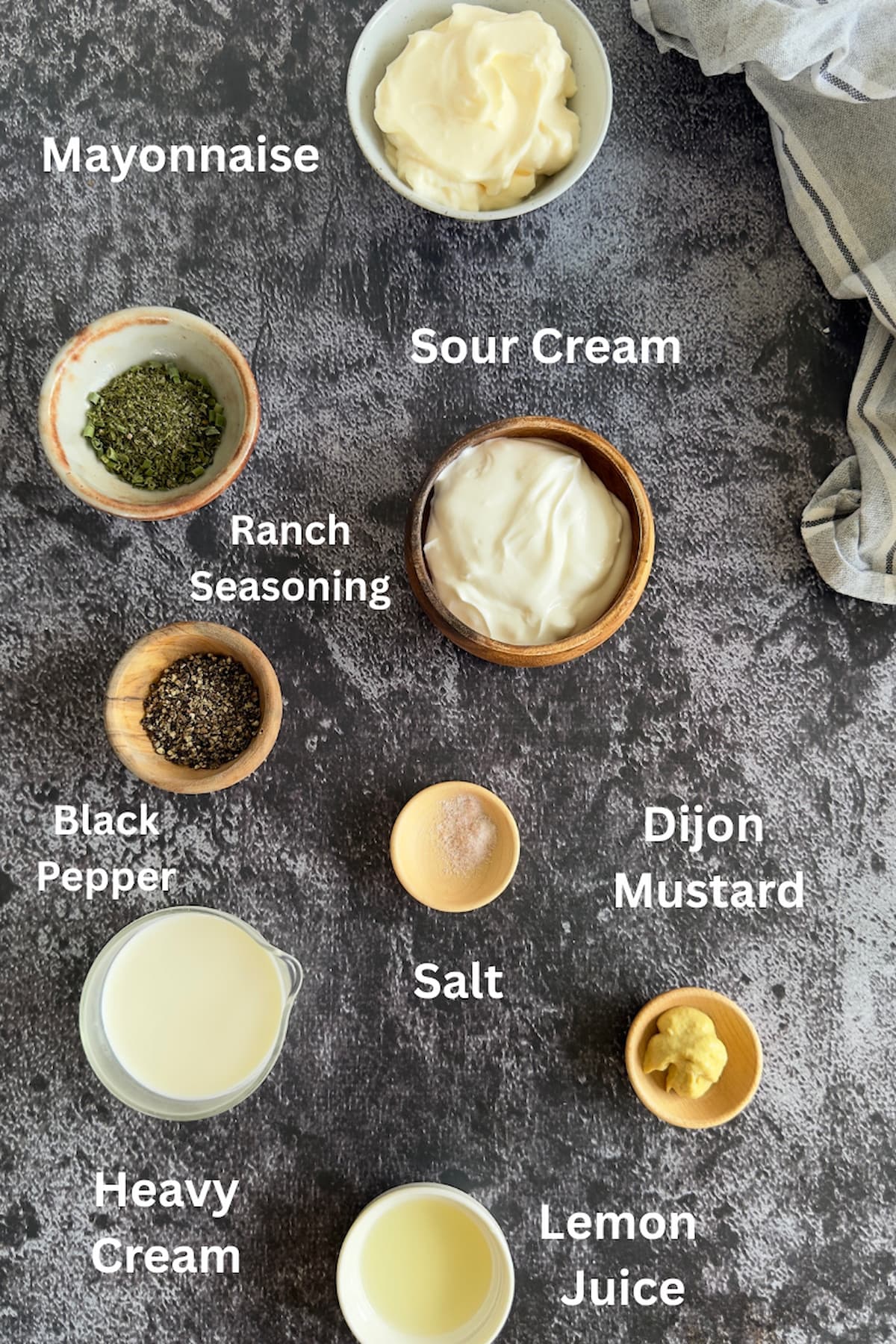 ingredients for peppercorn ranch sauce spread out in small bowls - mayonnaise, sour cream, heavy cream, black pepper, ranch seasoning, lemon juice, salt, dijon mustard