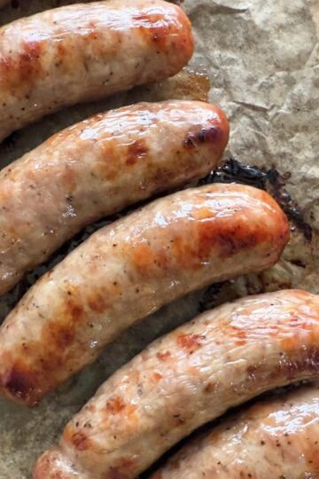 baked brats on a piece of parchment paper.
