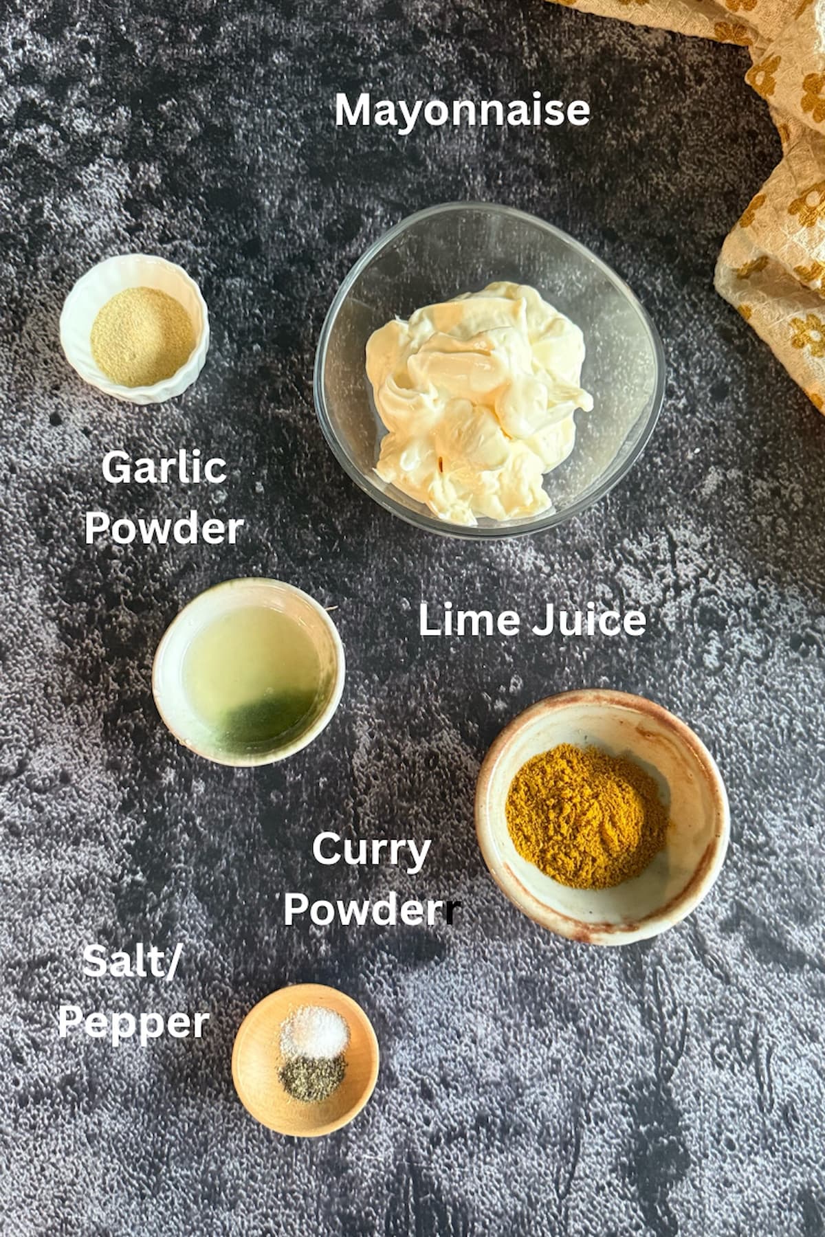 curry mayo ingredients laid out in small bowls - mayonnaise, lime juice, salt, pepper, garlic powder, curry powder.