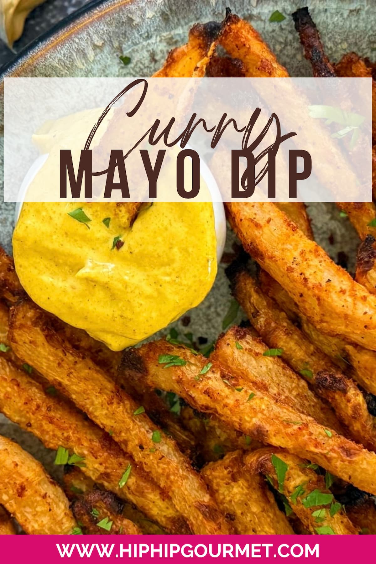 fries with fresh chopped parsley on a plate next to a bright yellow curry dipping sauce. fry dipping into the ramekin of curry sauce.